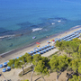 Luftaufnahme eines Strandes mit Sonnenschirmen und klarem, blauem Meer in Piombino.