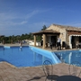 Swimmingpool mit Sonnenterrasse und Liegestühlen in einer Hotelanlage.