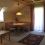 Gemütliches Wohnzimmer mit Esstisch, Sofa und Teppich in einer Ferienwohnung.