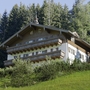 Ein Landhaus in Salzburg umgeben von Bäumen und Wiese.