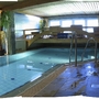 Innenpool mit Wandbild eines Regenbogens und Pflanzen im Landhaus Salzburg.
