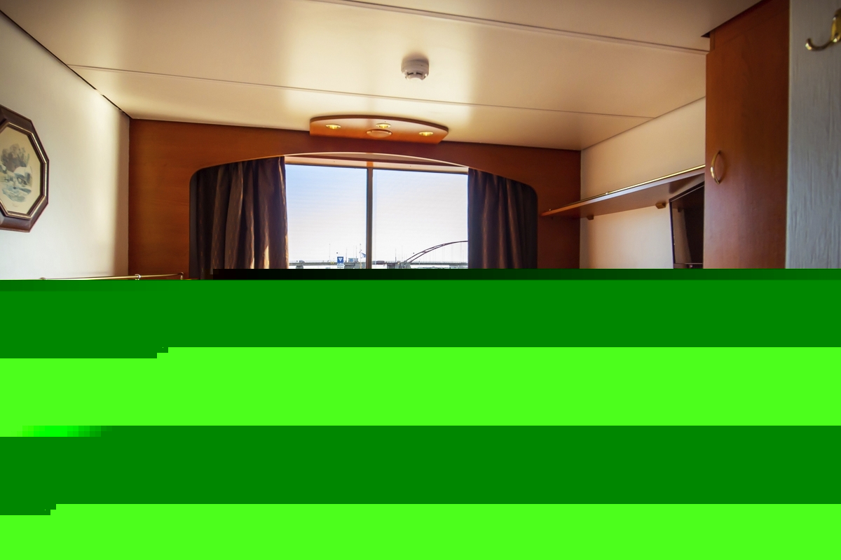 Kabine mit zwei Betten, Fenster mit Aussicht auf eine Brücke im Hintergrund.
