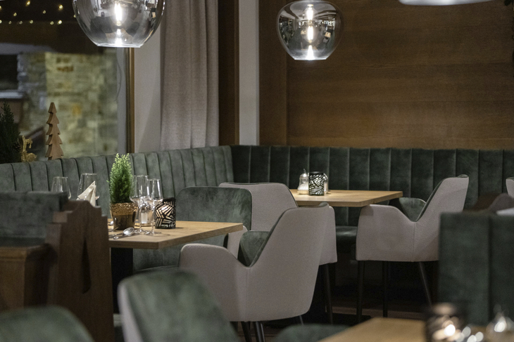 Restaurant-Innenansicht mit gedeckten Tischen und moderner Einrichtung.