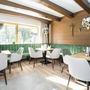 Restaurant-Innenraum mit grüner Sitzbank, Holzwänden und modernen Hängelampen.