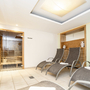 Innenansicht einer modernen Sauna mit Liegestühlen und Holzvertäfelung.