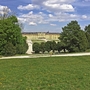 Blick auf das Schloss Schönbrunn in Wien mit Bäumen und Wiese im Vordergrund.