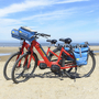 Zwei rote Fahrräder am Strand von Zeeland mit Meer im Hintergrund.