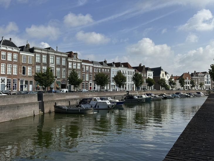 Reihen von Gebäuden und Boote entlang eines Kanals bei klarem Himmel in Middelburg.