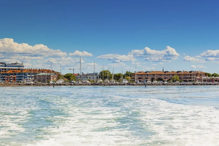 Küste von Grado mit Booten und blauen Himmel im Hintergrund.