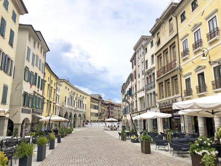 Straßencafé und historische Gebäude in einer Altstadt unter blauem Himmel