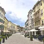 Straßencafé und historische Gebäude in einer Altstadt unter blauem Himmel