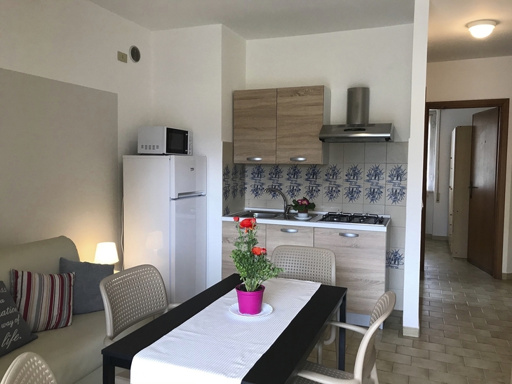 Moderne Küche mit Esstisch, Stühlen und Blumen, helles und schlichtes Design.