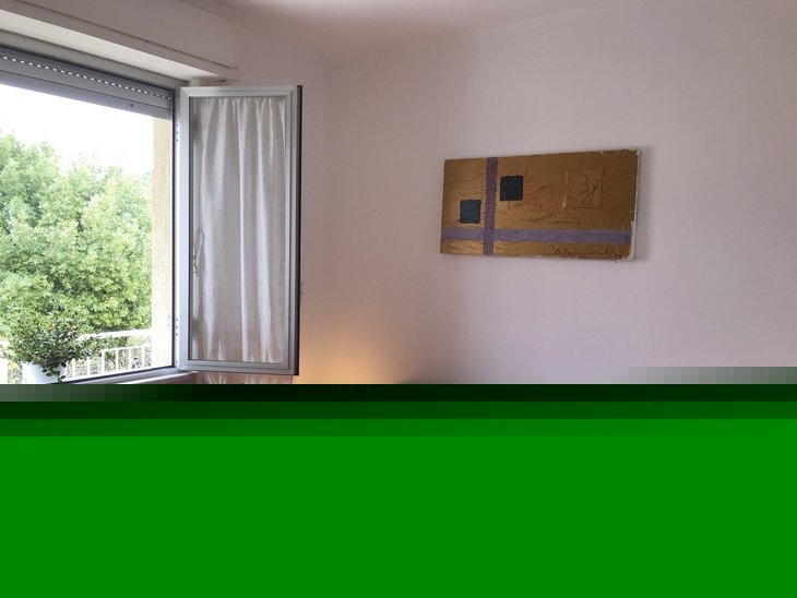 Schlafzimmer mit rotem Bett, offenem Fenster und Wandbild, zwei Nachttischen mit Lampen.