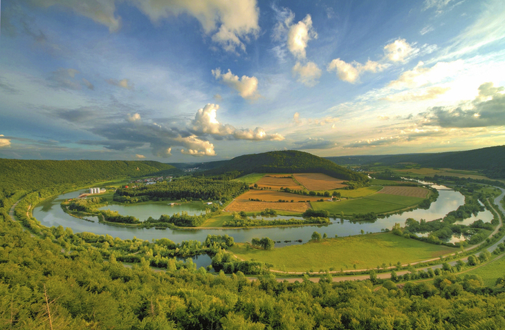 Malerische Landschaft im Altmühltal mit Fluss und Feldern unter blauem Himmel