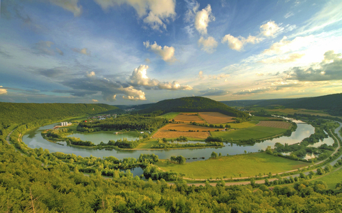 Malerische Landschaft im Altmühltal mit Fluss und Feldern unter blauem Himmel