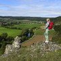 Wanderer mit rotem Rucksack blickt von Aussichtspunkt auf das Altmühltal.