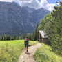 Wanderer auf Bergweg vor beeindruckender Alpenkulisse am Lechweg.