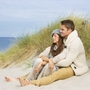 Paar sitzt im Winter am Strand der Nordsee.