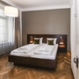Schlafzimmer mit Doppelbett und Holzfußboden in moderner Einrichtung.