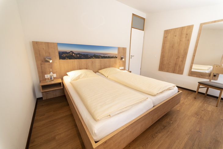 Schlafzimmer mit Doppelbett und Holzmöbeln in einem Ferienhaus.