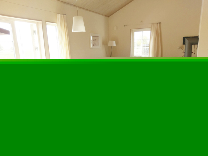 Helles Wohnzimmer mit Esstisch, Stühlen und Sofa, mit Blick ins Freie.