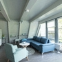 Wohnbereich eines Ferienhauses mit blauer Couch und großem Fenster im Ferienpark Ronshausen.