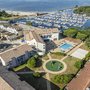 Luftaufnahme einer Ferienanlage mit Pool und Spielplatz am Hafen von Hourtin.