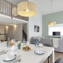 Esszimmer mit gedecktem Tisch und Blick auf Wohnzimmer in moderner Ferienwohnung.
