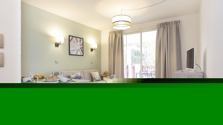 Wohnbereich mit Esstisch, Sofa, Wandbildern und Zugang zu einem Balkon.