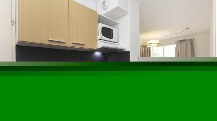 Kleine, moderne Küchenzeile in Ferienwohnung mit Blick ins Wohnzimmer.