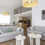 Modern eingerichtetes Wohnzimmer mit Sofas und Esstisch, helle und minimalistische Dekoration.