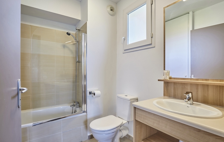 Modernes Badezimmer mit Badewanne, Waschbecken und WC.