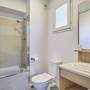 Modernes Badezimmer mit Badewanne, Waschbecken und WC.