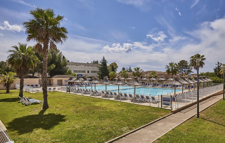 Poolbereich der Résidence Odalys Les Océanides in La Londe-les-Maures mit Liegen und Palmen.