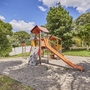 Spielplatz mit Klettergerüst und Rutsche im Freien bei sonnigem Wetter