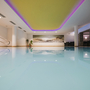 Hallenbad mit beleuchteter Decke und Wandbild in einem modernen Spa-Bereich.
