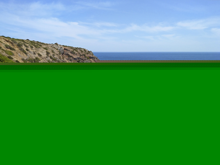 Küste mit Klippen und blauem Meer unter klarem Himmel.