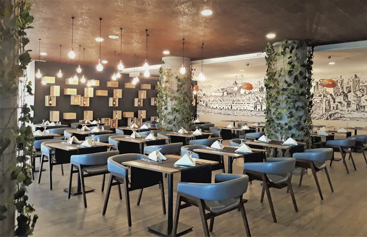 Modernes Restaurant mit Holzmöbeln und Wanddekoration im Hotel Maria Nova an der Algarve.