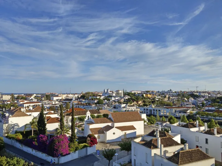 Stadtpanorama von Tavira, Portugal, mit blauen Himmel und weißen Gebäuden.