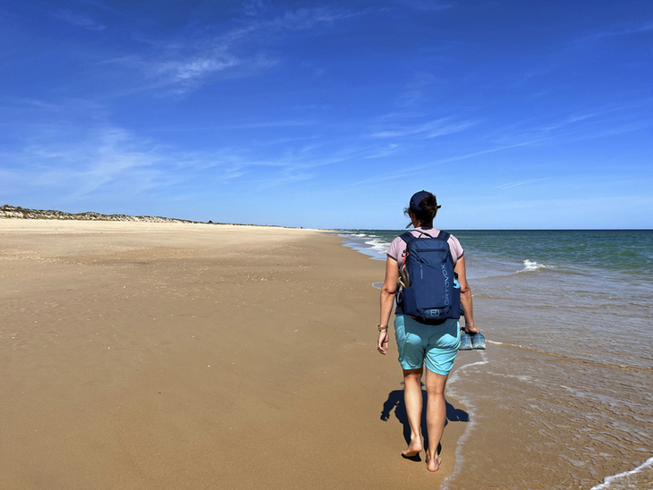 Person wandert allein am Strand von Ilha de Tavira, Algarve, Portugal.