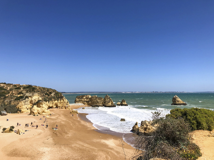 Sandstrand mit Felsen und blauem Himmel an der Algarve, Portugal.