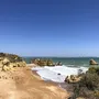 Sandstrand mit Felsen und blauem Himmel an der Algarve, Portugal.