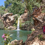 Wasserfall Pego do Inferno in Portugal mit Rucksack und Wanderstöcken im Vordergrund.