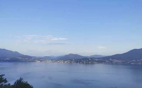 Blick auf einen See mit Bergen im Hintergrund bei klarem Himmel.