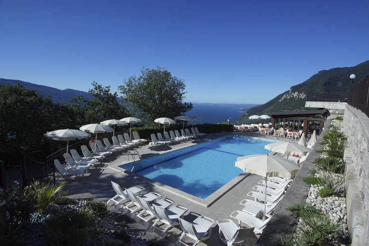 Pool mit Sonnenliegen, Pizzeria und Blick auf einen See in Tignale.