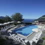Pool mit Sonnenliegen, Pizzeria und Blick auf einen See in Tignale.
