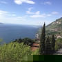 Blick auf den Gardasee und umliegende Berge bei Tignale bei klarem Himmel.
