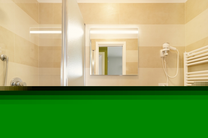Badezimmer mit Spiegel, Waschbecken, Duschkabine und Handtuchheizung.