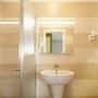 Badezimmer mit Spiegel, Waschbecken, Duschkabine und Handtuchheizung.