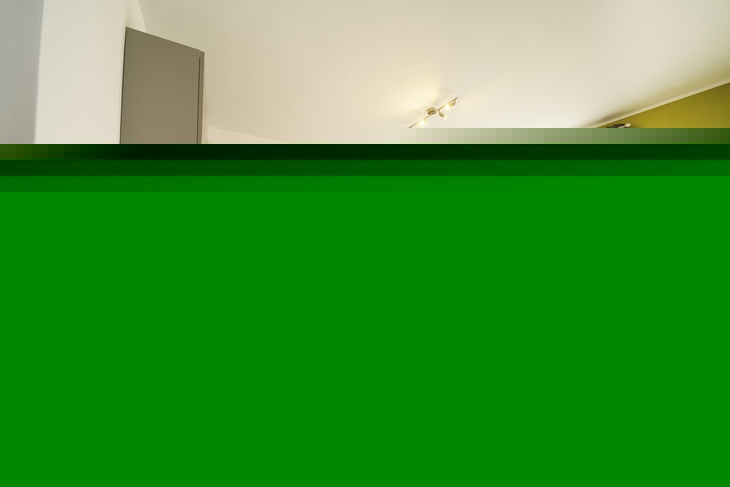 Helle Ferienwohnung mit Küche, Esstisch, Sofa und Balkon.
